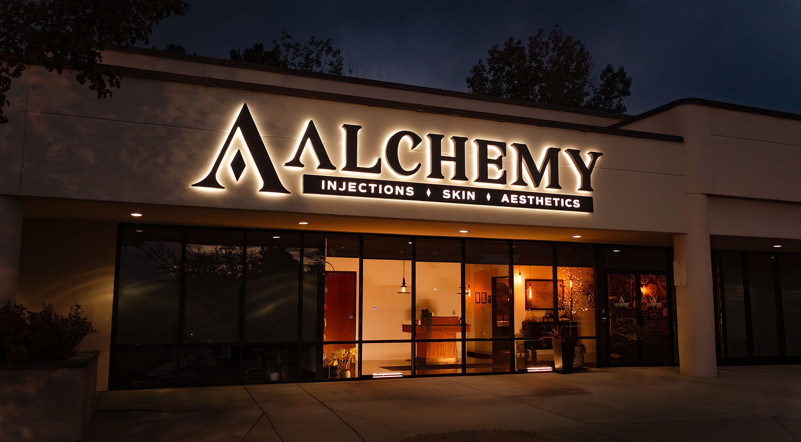 Alchemy skin and aesthetics clinic storefront at night